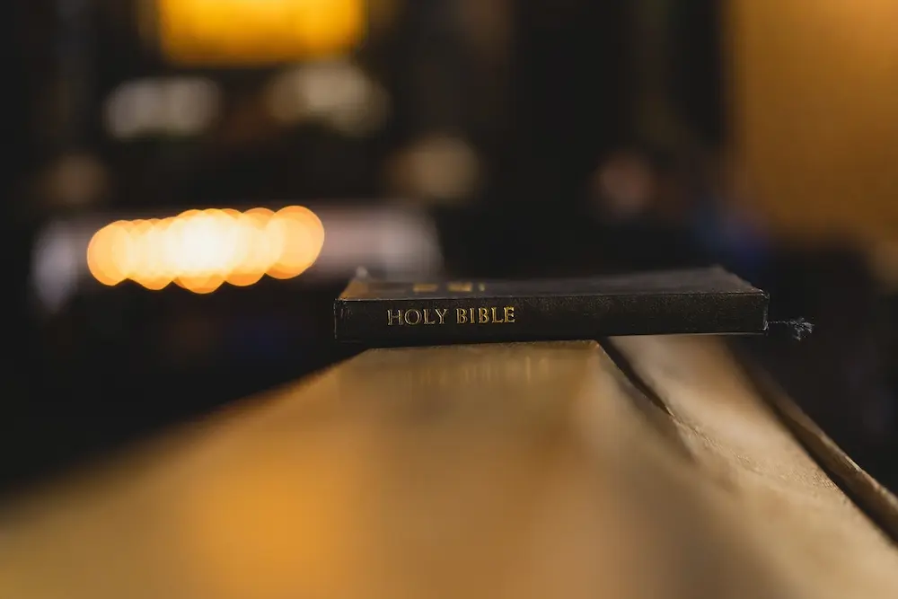 A Bible sits on a church pew.